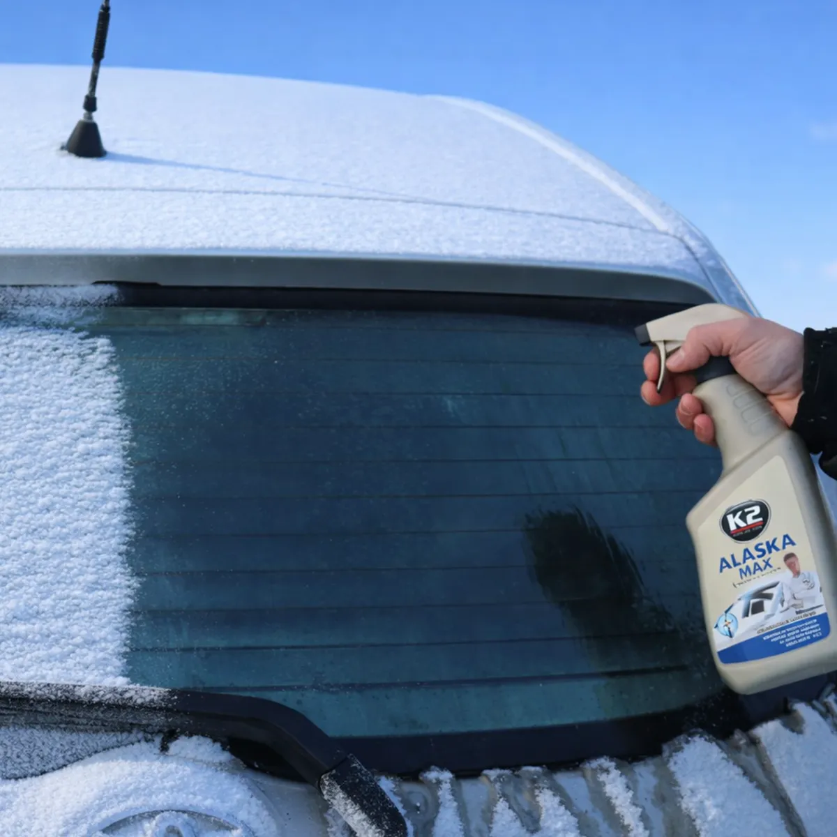 K2 Alaska Max hrímeyði úðað á ísaða afturrúðu bíls.
