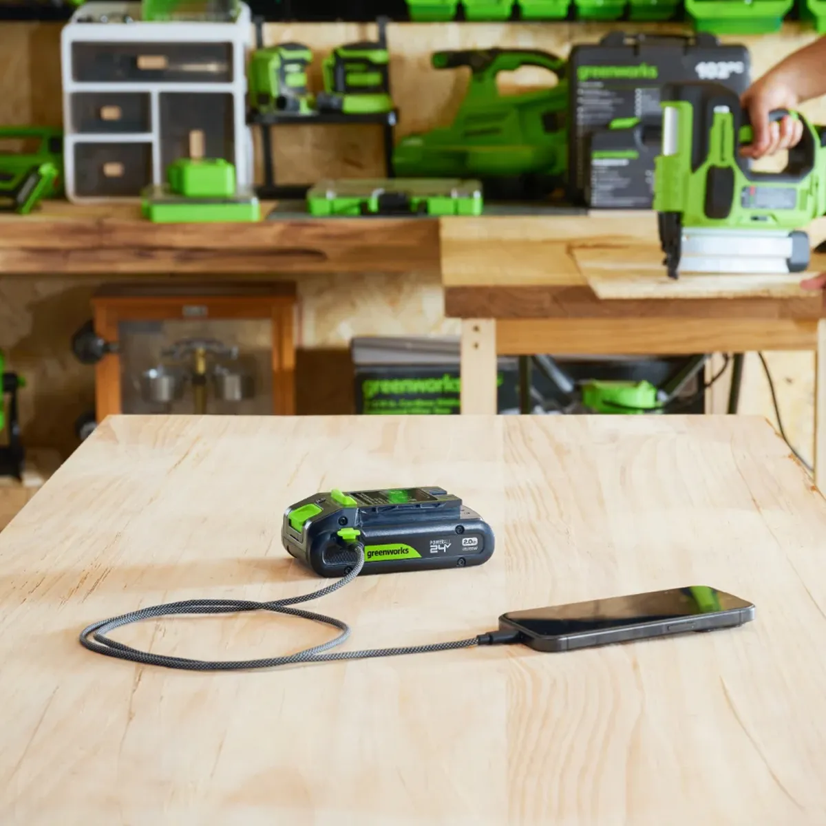 Sími tengdur Greenworks USB-C rafhlöðu á vinnuborði